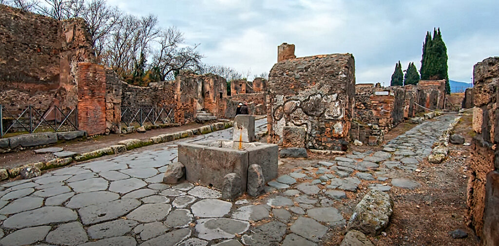 Public fountain in a split street Pompeii Walk