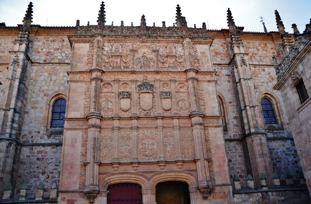 Portada de piedra de la Universidad de Salamanca, cubierta de relieves y escudos sobre dos puertas